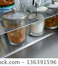 Thai noodle seasoning set in glass jars with stainless steel lids on a street food table 136391596