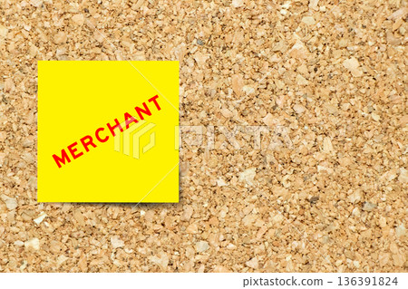 Yellow note paper with word merchant on cork board background with copy space 136391824