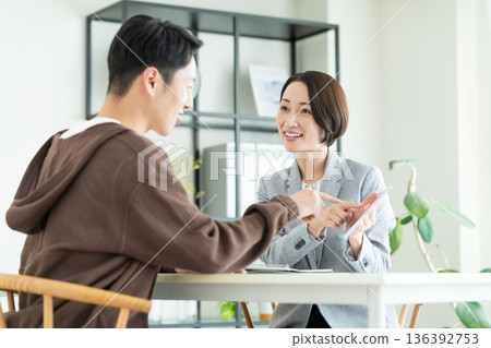 A businesswoman explaining to a middle-aged man A businesswoman explaining to a middle-aged man 136392753