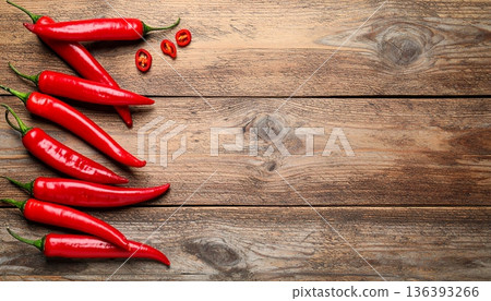 Ripe red chili peppers on wooden table, flat lay. Space for text Ripe red chili peppers on wooden table, flat lay. Space for text 136393266