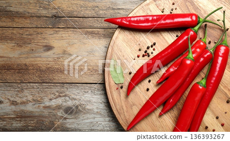 Ripe red chili peppers on wooden table, flat lay. Space for text 136393267