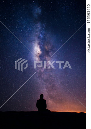 A male astronomer is seen from behind, silhouetted against a breathtaking view of the Milky Way galaxy A male astronomer is seen from behind, silhouetted against a breathtaking view of the Milky Way galaxy 136393460