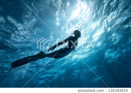 A dynamic shot of a freediver performing a powerful monofin kick, propelling through the water with incredible speed and grace. 136393654