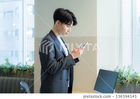 A businessman who uses a smartphone in the office 136394143