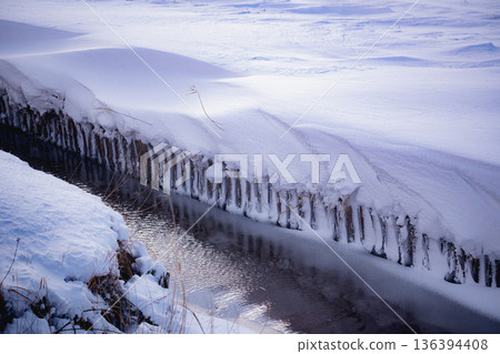 白雪覆蓋的稻田和灌溉渠道:冬季農業水道和雪田的景色 白雪覆蓋的稻田和灌溉渠道:冬季農業水道和雪田的景色 136394408