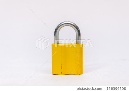 Yellow metal padlock on a light isolated background. 136394508