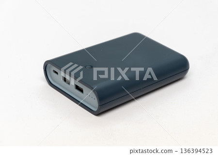 Gray external battery for charging devices on a light background. 136394523
