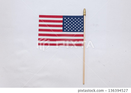 American flag on a wooden stick stands on a light background. American flag on a wooden stick stands on a light background. 136394527