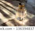 Luxury perfume bottle with golden liquid illuminated by soft light. Premium beauty and fragrance concept, high end branding, fashion concepts, cosmetic advertising and elegant lifestyle visuals. 136394837