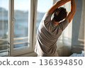 Faceless young man doing morning stretch with stretching the back by window. Wellness morning routine. Flexibility, relaxation, mindfulness, active healthy lifestyle, daily movement, morning body care 136394850