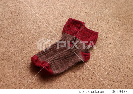 紅棕色的襪子平鋪在軟木背景上。秋冬季保暖的日常必需品。 紅棕色的襪子平鋪在軟木背景上。秋冬季保暖的日常必需品。 136394883