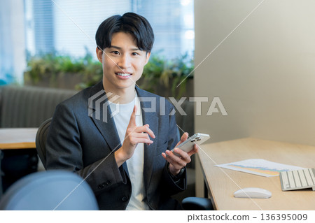 一個在辦公室使用智能手機的商人 136395009
