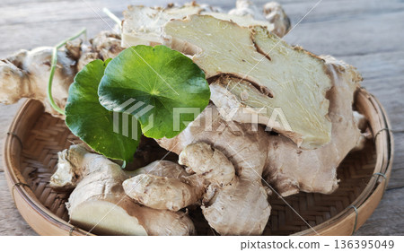 Ginger and gotu kola leaves in a basket. 136395049