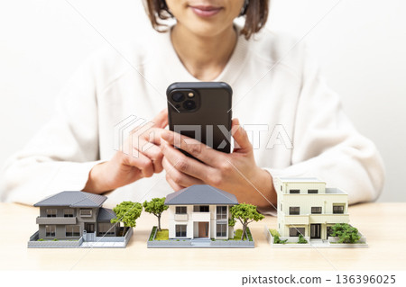 A woman comparing house models 136396025
