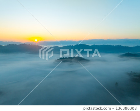Aerial view of flowing fog waves on mountain tropical rainforest,Bird eye view image over the clouds Amazing nature background with clouds and mountain peaks in Thailand Aerial view of flowing fog waves on mountain tropical rainforest,Bird eye view image over the clouds Amazing nature background with clouds and mountain peaks in Thailand 136396308