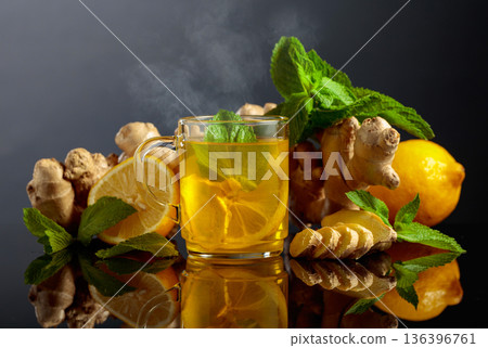 Ginger tea with lemon and mint on a black background. Ginger tea with lemon and mint on a black background. 136396761