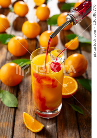 Tequila sunrise cocktail on an old wooden table. 136396770