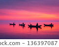 The serene scene of traditional Malawian fishing boats (dugout canoes), gently floating on the calm, vast expanse of Lake Malawi at sunrise. 136397087