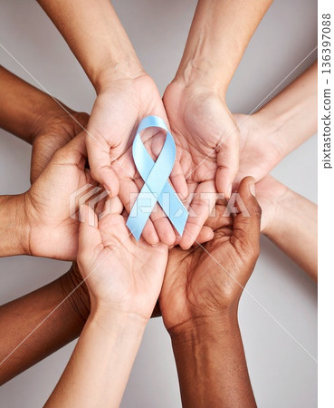 A diverse group of hands holds a diabetes awareness ribbon, symbolizing unity and collective support. 136397088