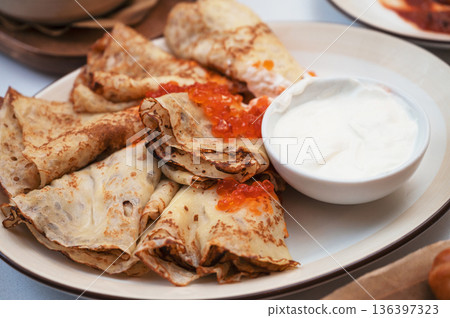 Crepes with red caviar and sour cream Crepes with red caviar and sour cream 136397323
