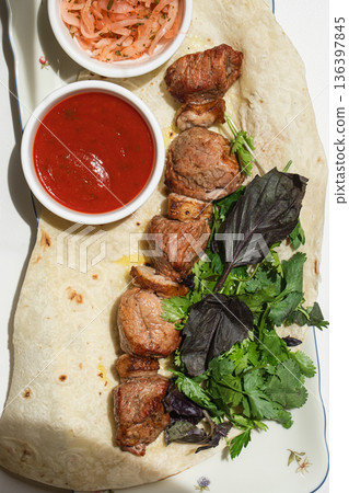 Caucasian lamb shashlik with red sauce and onions Caucasian lamb shashlik with red sauce and onions 136397845