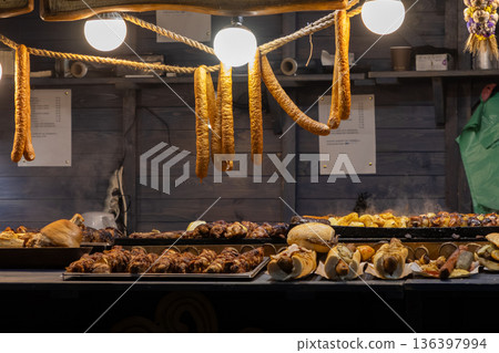 Festive food stall featuring delicious grilled sausages, hot dogs, and skewers, creating a warm, inviting atmosphere for a traditional culinary street market event 136397994