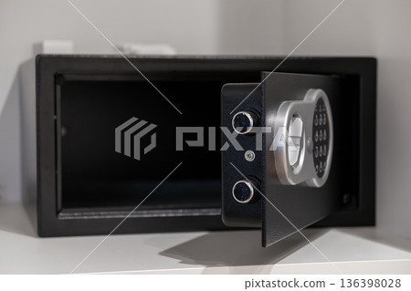 Empty open black electronic safe with a digital keypad and silver handle, representing secure storage for valuables in home or hotel environments 136398028