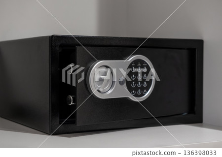 Sleek black digital safe with an open door and visible locking bolts, emphasizing robust security for valuables in modern hotel rooms or secure home storage 136398033