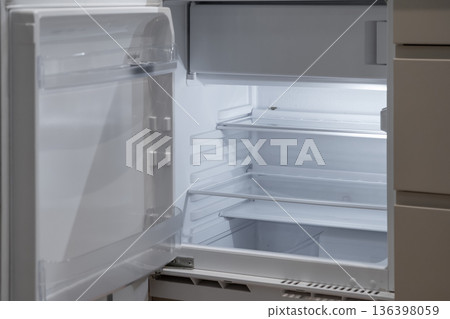 Modern open white empty refrigerator interior with bright light illuminating its adjustable shelves, representing household scarcity, a healthy diet, or fresh beginnings Modern open white empty refrigerator interior with bright light illuminating its adjustable shelves, representing household scarcity, a healthy diet, or fresh beginnings 136398059