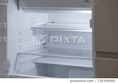 Clean empty refrigerator interior with multiple shelves and no food, symbolizing scarcity, new appliance purchase, or economic challenges Clean empty refrigerator interior with multiple shelves and no food, symbolizing scarcity, new appliance purchase, or economic challenges 136398060