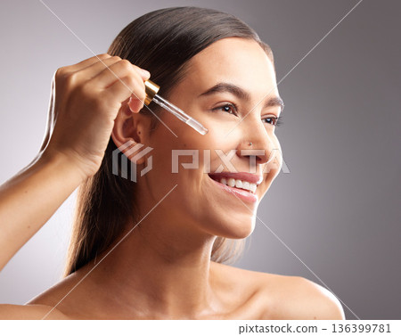 Beauty, face and happy woman with serum dropper for skincare hydration, facial cosmetics glow or anti aging wellness. Collagen oil treatment, dermatology and studio person on gradient grey background Beauty, face and happy woman with serum dropper for skincare hydration, facial cosmetics glow or anti aging wellness. Collagen oil treatment, dermatology and studio person on gradient grey background 136399781