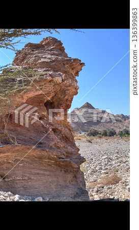Imposing Rock Formation With Sharp Outline. Striking Sandstone Formation With Dramatic Shadowing Details. Breathtaking Mountain Profile Against Bright Sky With Textured Surfaces Imposing Rock Formation With Sharp Outline. Striking Sandstone Formation With Dramatic Shadowing Details. Breathtaking Mountain Profile Against Bright Sky With Textured Surfaces 136399863