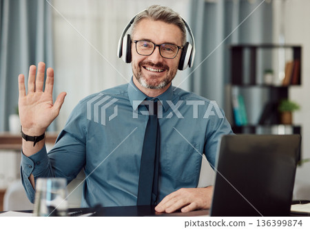 Portrait, headphones and man wave on video call for business smile in online chat at home. Happy face, hello and webinar of mature manager with glasses in virtual meeting for remote work on laptop Portrait, headphones and man wave on video call for business smile in online chat at home. Happy face, hello and webinar of mature manager with glasses in virtual meeting for remote work on laptop 136399874