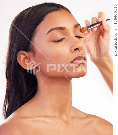 Beauty, makeup and brush on face of woman in studio for cosmetics, foundation and eyeshadow. Salon, self care and glow with female model on white background for application, powder and facial Beauty, makeup and brush on face of woman in studio for cosmetics, foundation and eyeshadow. Salon, self care and glow with female model on white background for application, powder and facial 136400119