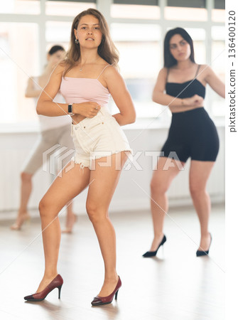 Expressive young girl partaking in group sass dance class Expressive young girl partaking in group sass dance class 136400120