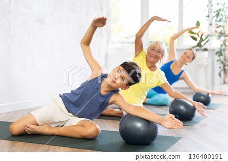 Mom son and grandmother perform physical exercise with softball on karemat Mom son and grandmother perform physical exercise with softball on karemat 136400191