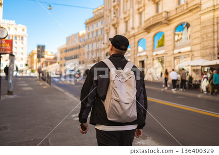 Tourist with backpack walking along city street in Rome Tourist with backpack walking along city street in Rome 136400329