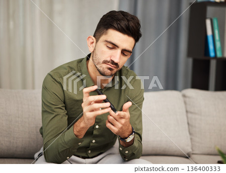 Man, diabetes and blood sugar check with pen for healthcare and insulin monitor at home. Male person, medical test and glucose analysis in a living room with medicine, care and clinic tool in a house 136400333