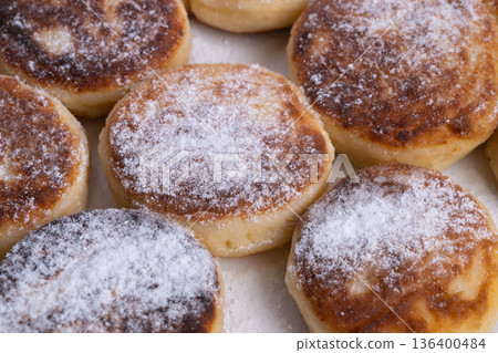 Detailed image showcasing dense cheese centers and light sugar dusting, An indepth visual of nutritious syrniki with textured centers and delicate sugar sprinkle 136400484