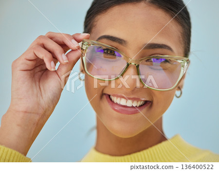 Woman portrait, glasses and vision with blue light frame with a smile with ophthalmology. Isolated, studio background and happy person with eye care, wellness and health of a girl with eyewear Woman portrait, glasses and vision with blue light frame with a smile with ophthalmology. Isolated, studio background and happy person with eye care, wellness and health of a girl with eyewear 136400522