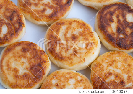 Plated golden syrniki for cozy brunch, cafstyle presentation suggesting butter and jam pairing, warm tones and rustic table mood ideal for menus and social content 136400523