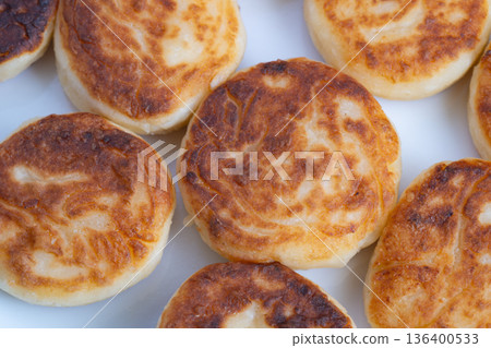 Crispy exterior with creamy center, Artisan styled photograph highlighting syrniki features, Detailed image of syrniki showing contrast between crust and creamy filling 136400533