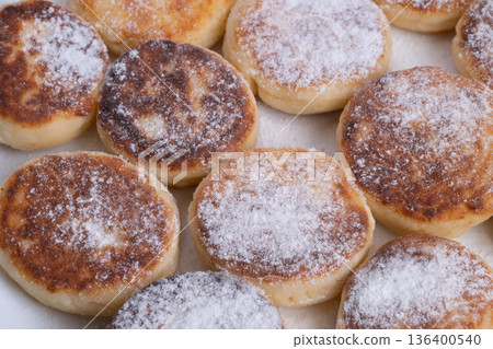 Rustic breakfast with crispy edges, Cozy homemade breakfast with golden syrniki on rustic tray, Closeup view of golden syrniki dusted with sugar on cozy rustic breakfast tray Rustic breakfast with crispy edges, Cozy homemade breakfast with golden syrniki on rustic tray, Closeup view of golden syrniki dusted with sugar on cozy rustic breakfast tray 136400540