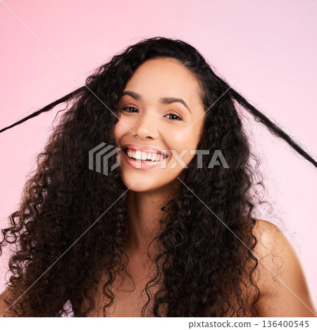 Face, woman and curly hair pull for beauty in studio isolated on a pink background. Portrait, natural cosmetics and hairstyle of happy model in salon treatment for growth, wellness and aesthetic 136400545