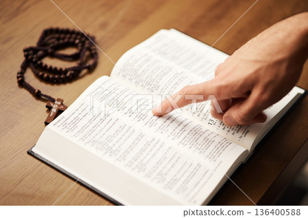 Hands, person and reading bible with rosary cross for praying, spiritual faith and holy worship of God. Closeup of christian studying religion, gospel prayer books and learning praise to Jesus Christ Hands, person and reading bible with rosary cross for praying, spiritual faith and holy worship of God. Closeup of christian studying religion, gospel prayer books and learning praise to Jesus Christ 136400588