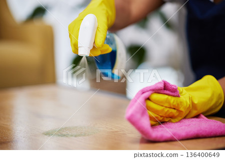 Spray, hands and person cleaning table, furniture and housekeeping services at home. Closeup of cleaner wipe surface with cloth, bottle of chemical product and disinfection of dust, bacteria and dirt 136400649