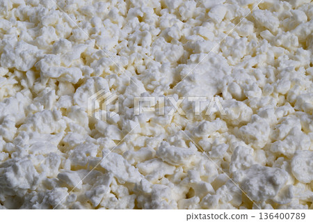 White cottage cheese granules closeup background, repetitive granular pattern, soft shadows, macro perspective for packaging and web banners, neutral culinary backdrop 136400789