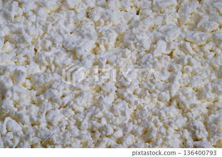 Largescale cottage cheese curds with granular surface for industrial use, Massive quantities of cottage cheese curds featuring dense texture suitable for food production needs 136400793