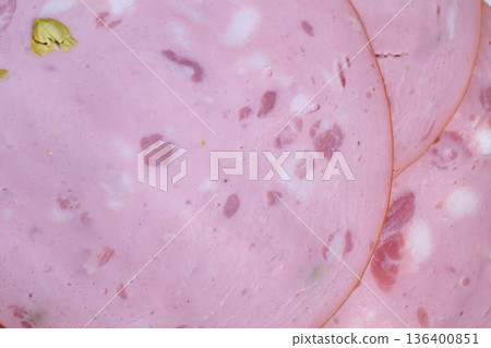 Closeup pink mortadella slices with pistachio glossy texture dotted with fat cubes and green nut, evoking tactile appeal for food styling and ingredient photography Closeup pink mortadella slices with pistachio glossy texture dotted with fat cubes and green nut, evoking tactile appeal for food styling and ingredient photography 136400851