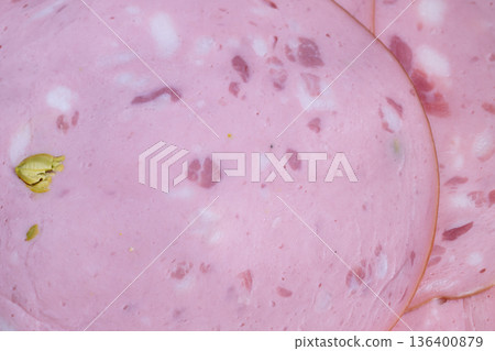 Processed sausage slices with pistachio inclusions, closeup suggesting industrial slicing and quality control, uniform rounds ready for packaging and bulk distribution Processed sausage slices with pistachio inclusions, closeup suggesting industrial slicing and quality control, uniform rounds ready for packaging and bulk distribution 136400879